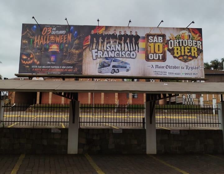 Outdoor com adesivação externa divulgando festas de uma casa de eventos